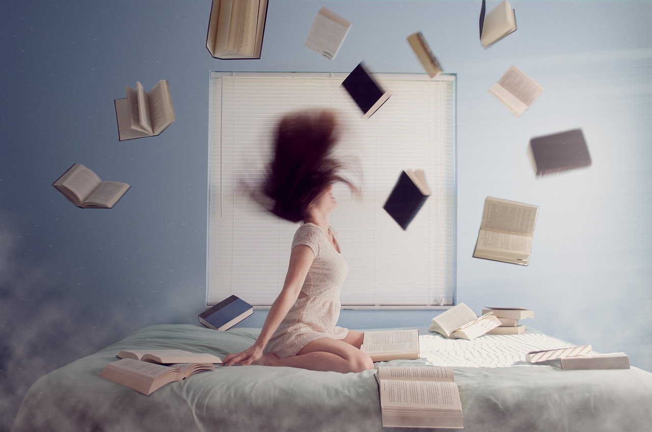 Femme dans un lit avec plein de livres